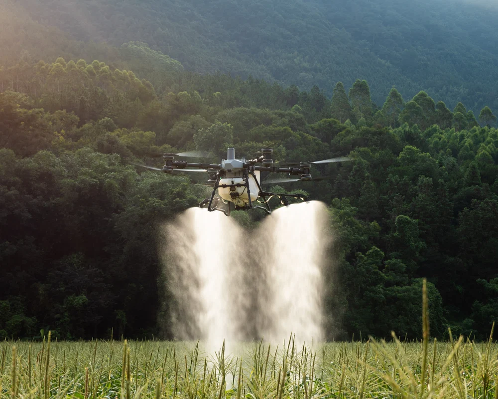 A DJI Agras T100 spraying a field
